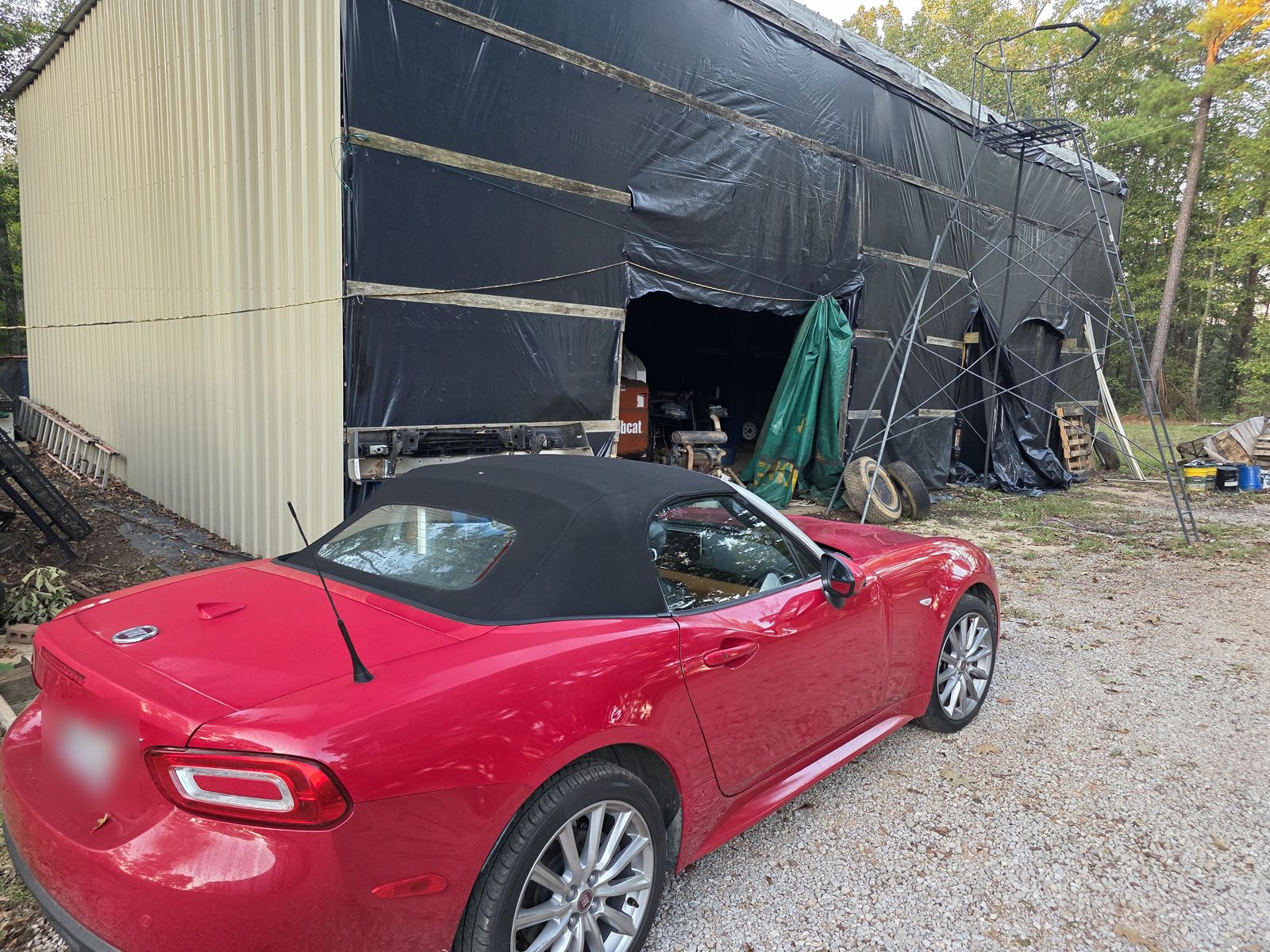 Red Fiat 124 Spider parked in front of the shop building